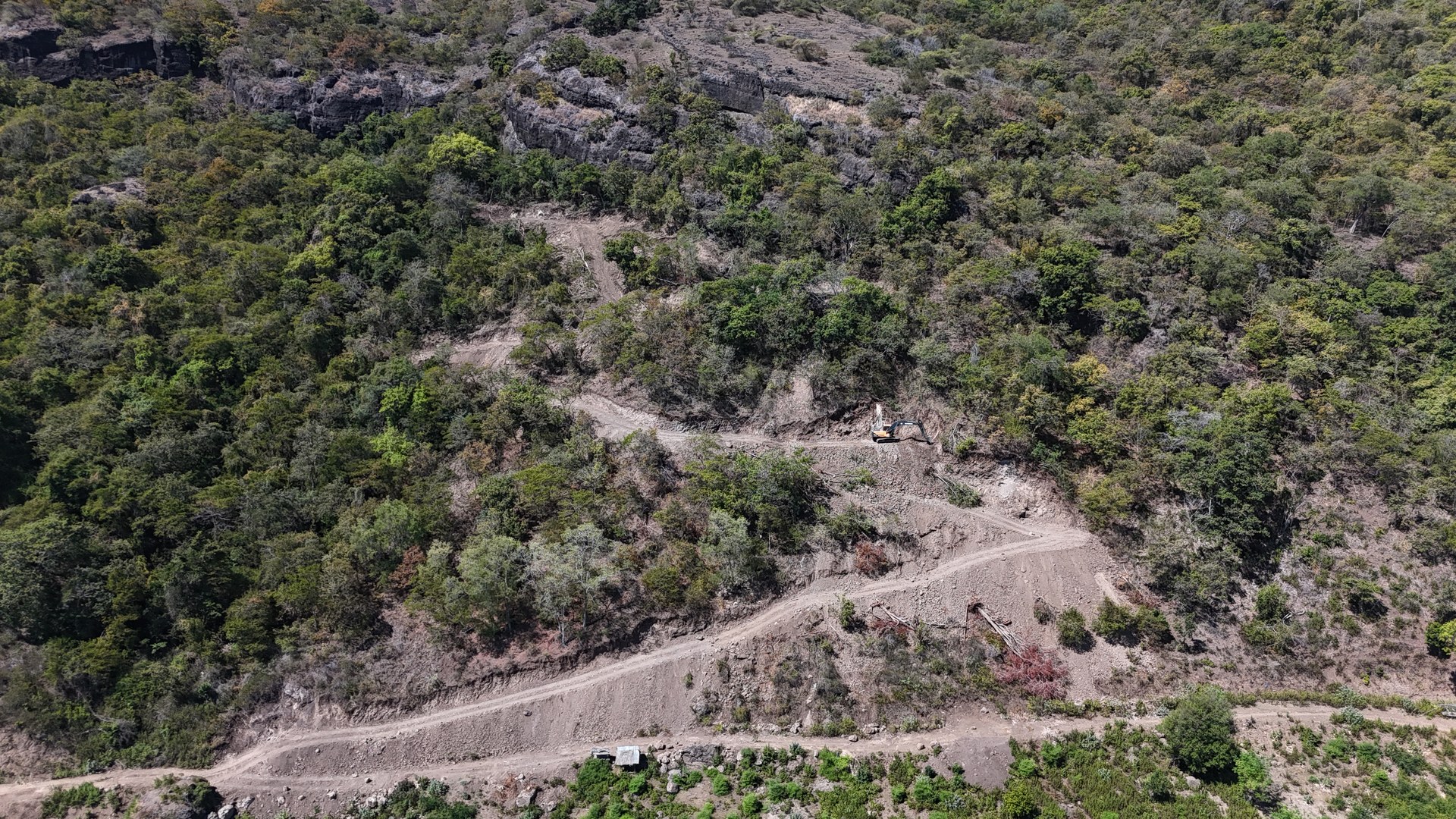 Aerial view of the Sumbawa beachfront land from inland, headland and surf break visible